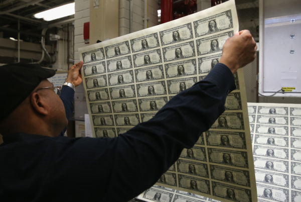 Giám sát viên In ấn Donavan Elliott kiểm tra các tờ tiền 1 USD mới in tại Cục Ấn Loát ở Hoa Thịnh Đốn, hôm 24/03/2015. (Ảnh: Mark Wilson/Getty Images)