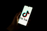 Một người đàn ông cầm điện thoại thông minh hiển thị logo của nền tảng mạng xã hội Trung Quốc TikTok hồi tháng 04/2024. (Ảnh: Antonin UTZ/AFP)
