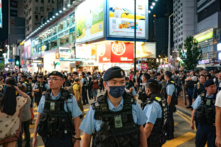 Hôm 04/06/2024, các sỹ quan cảnh sát tuần tra quận Vịnh Đồng La (Causeway Bay) của Hồng Kông gần Công viên Victoria, nơi hàng năm mọi người thường tề tựu để tưởng niệm các nạn nhân của cuộc đàn áp Thiên An Môn của Trung Quốc năm 1989. Kể từ khi luật an ninh quốc gia mới có hiệu lực, sự kiện này không còn diễn ra nữa. (Ảnh: Anthony Kwan/Getty Images)