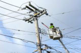 Các công nhân tiện ích sửa chữa dây điện ở Guerneville, California, vào ngày 09/01/2023. (Ảnh: Justin Sullivan/Getty Images)