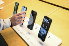 Một khách hàng so sánh các thiết bị Apple iPhone 15 được trưng bày để bán tại cửa hàng bán lẻ The Grove Apple trong ngày ra mắt tại Los Angeles, California, vào ngày 22/09/2023. (Ảnh: Patrick T. Fallon/AFP qua Getty Images)