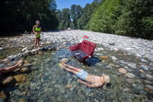 Một người đàn ông tắm mát trong làn nước lạnh giá ở Lynn Creek, Bắc Vancouver vào ngày 28/06/2021. (Ảnh: The Canadian Press/Darryl Dyck)