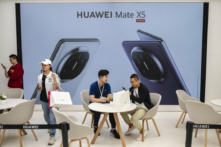Một khách hàng nói chuyện với nhân viên bán hàng khi nhận được chiếc điện thoại thông minh Mate 60 mới tại một cửa hàng hàng đầu của Huawei sau khi công ty này ra mắt các sản phẩm mới ở Bắc Kinh, Trung Quốc, hôm 25/09/2023. (Ảnh: Kevin Frayer/Getty Images)