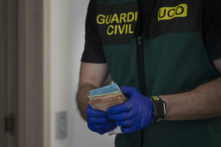 Các thành viên của Lực lượng Bảo vệ Dân sự Tây Ban Nha được Europol hậu thuẫn thu giữ những xấp tiền giấy ở Mijas, gần Malaga, Tây Ban Nha, hôm 12/06/2024. (Ảnh: Jorge Guerrero/AFP qua Getty Images)