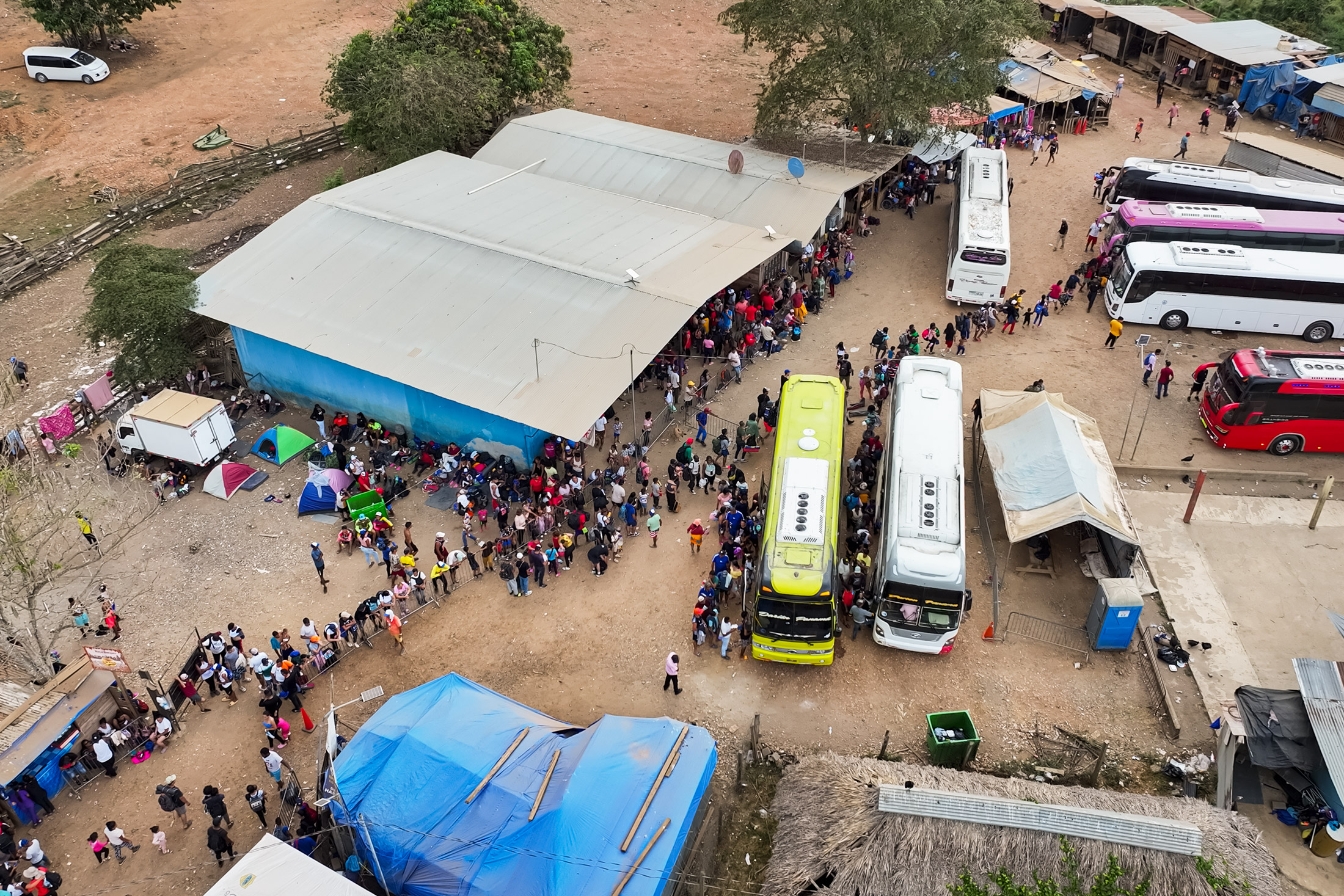 Những người nhập cư bất hợp pháp vượt qua rừng rậm Darién Gap vào Panama xếp hàng chờ xe buýt để đến Costa Rica, trong trại di cư Lajas Blancas ở Darién, Panama. (Ảnh: The Epoch Times)