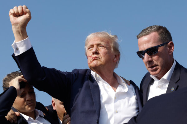 Cựu Tổng thống Donald Trump và là ứng cử viên tổng thống của Đảng Cộng Hòa giơ nắm đấm trong lúc được các nhân viên đẩy ra khỏi sân khấu trong một cuộc vận động tranh cử ở Butler, Pennsylvania, hôm 13/07/2024. (Ảnh: Anna Moneymaker/Getty Images)
