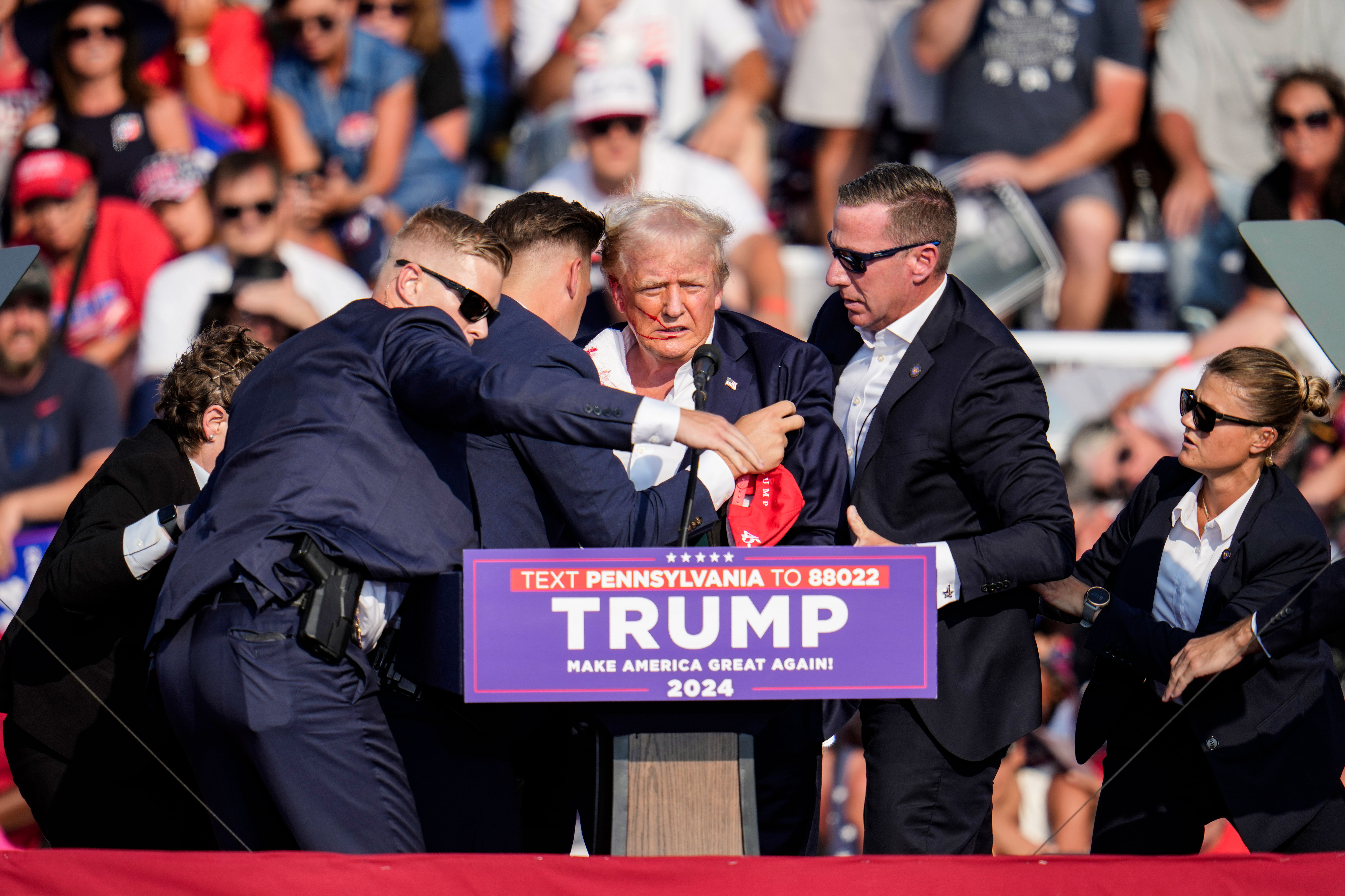Các nhân viên Sở Mật vụ Hoa Kỳ vây quanh cựu Tổng thống Trump trên sân khấu tại sự kiện vận động tranh cử. (Ảnh: Gene J. Puskar/AP Photo)