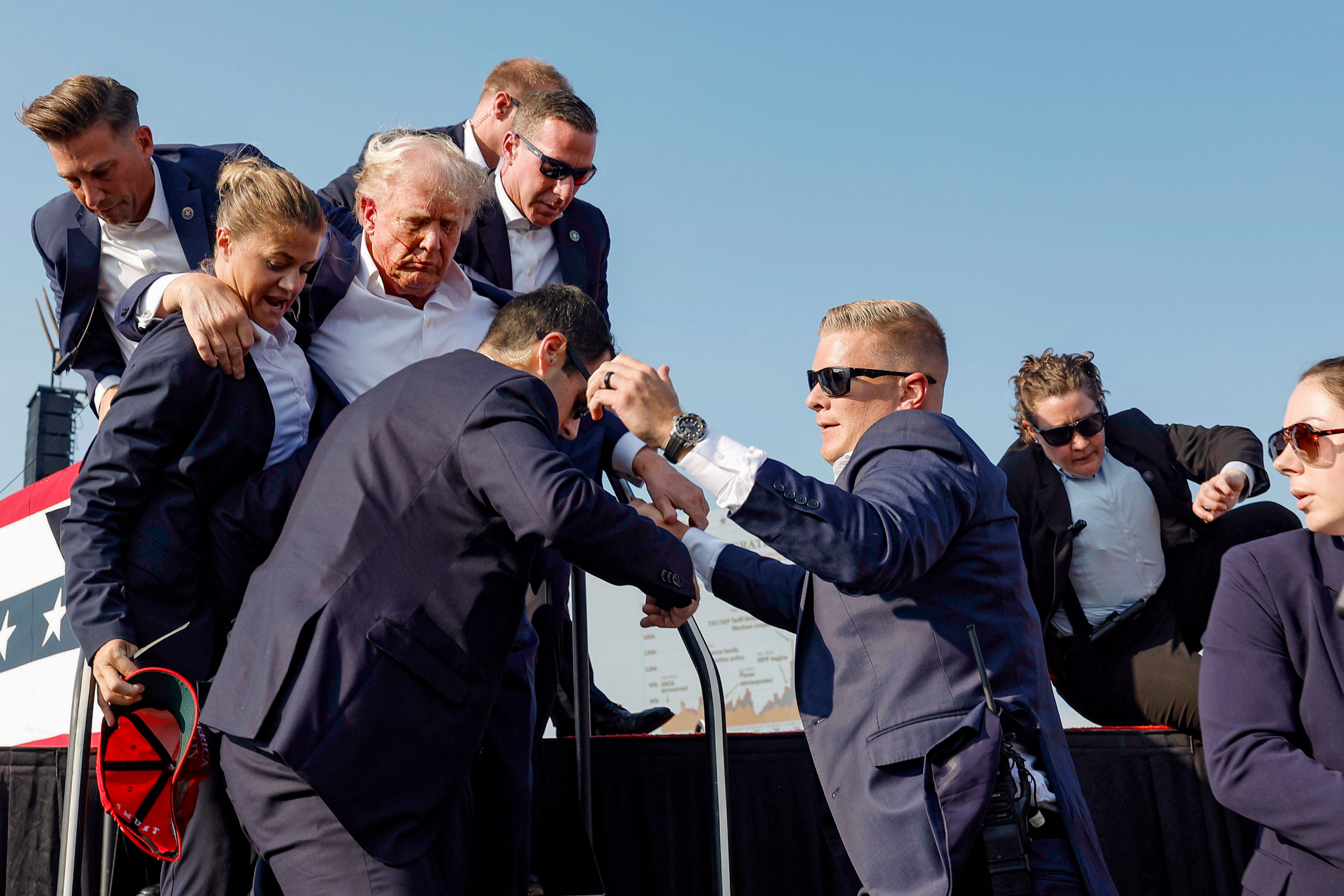 Cựu Tổng thống Trump được các nhân viên mật vụ Hoa Kỳ gấp rút đưa ra khỏi sân khấu. (Anna Moneymaker/Getty Images)