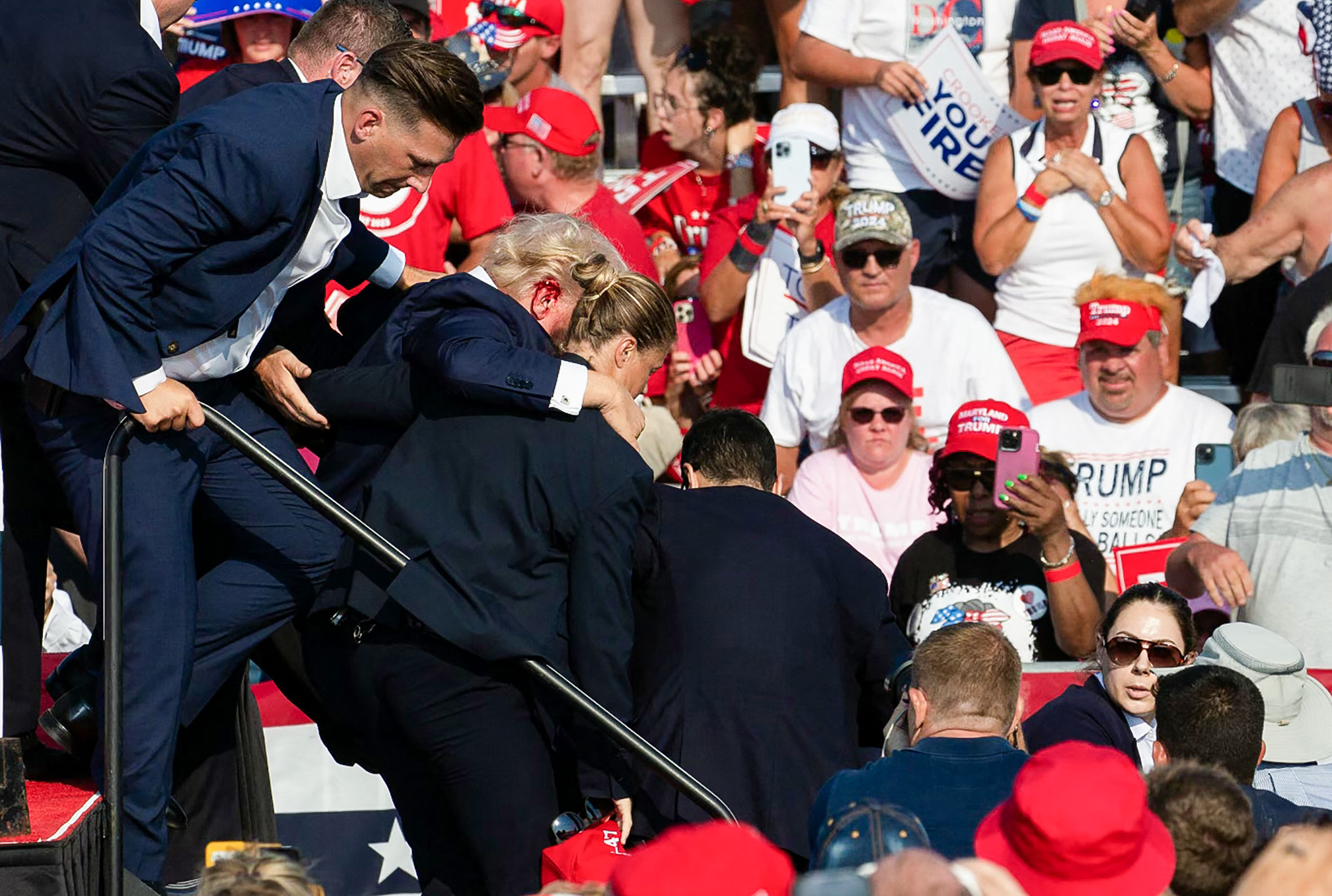 Cựu Tổng thống Donald Trump được giúp đỡ đưa xuống sân khấu tại sự kiện. (Ảnh: Rebecca Droke/AFP qua Getty Images)