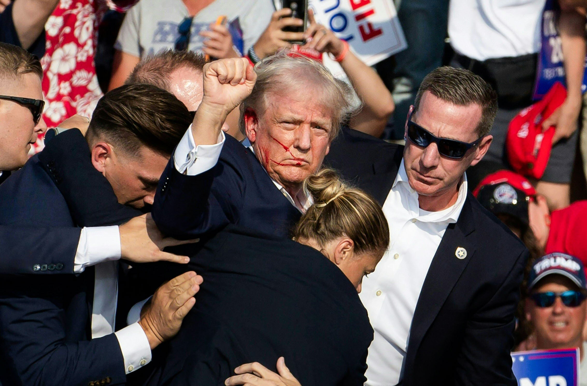 Các nhân viên Sở Mật vụ Hoa Kỳ vây quanh cựu Tổng thống Donald Trump khi hộ tống ông rời khỏi sân khấu. (Ảnh: Rebecca Droke/AFP qua Getty Images)