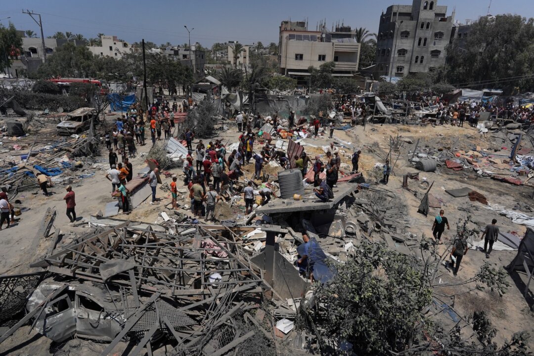Người Palestine nhìn đống đổ nát của những căn lều và công trình nhà ở tạm bợ bị phá hủy sau một cuộc tấn công của quân đội Israel vào trại al-Mawasi, gần thành phố Khan Yunis, phía nam Dải Gaza hôm 13/07/2024. (Ảnh: Bashar Taleb/AFP qua Getty Images)
