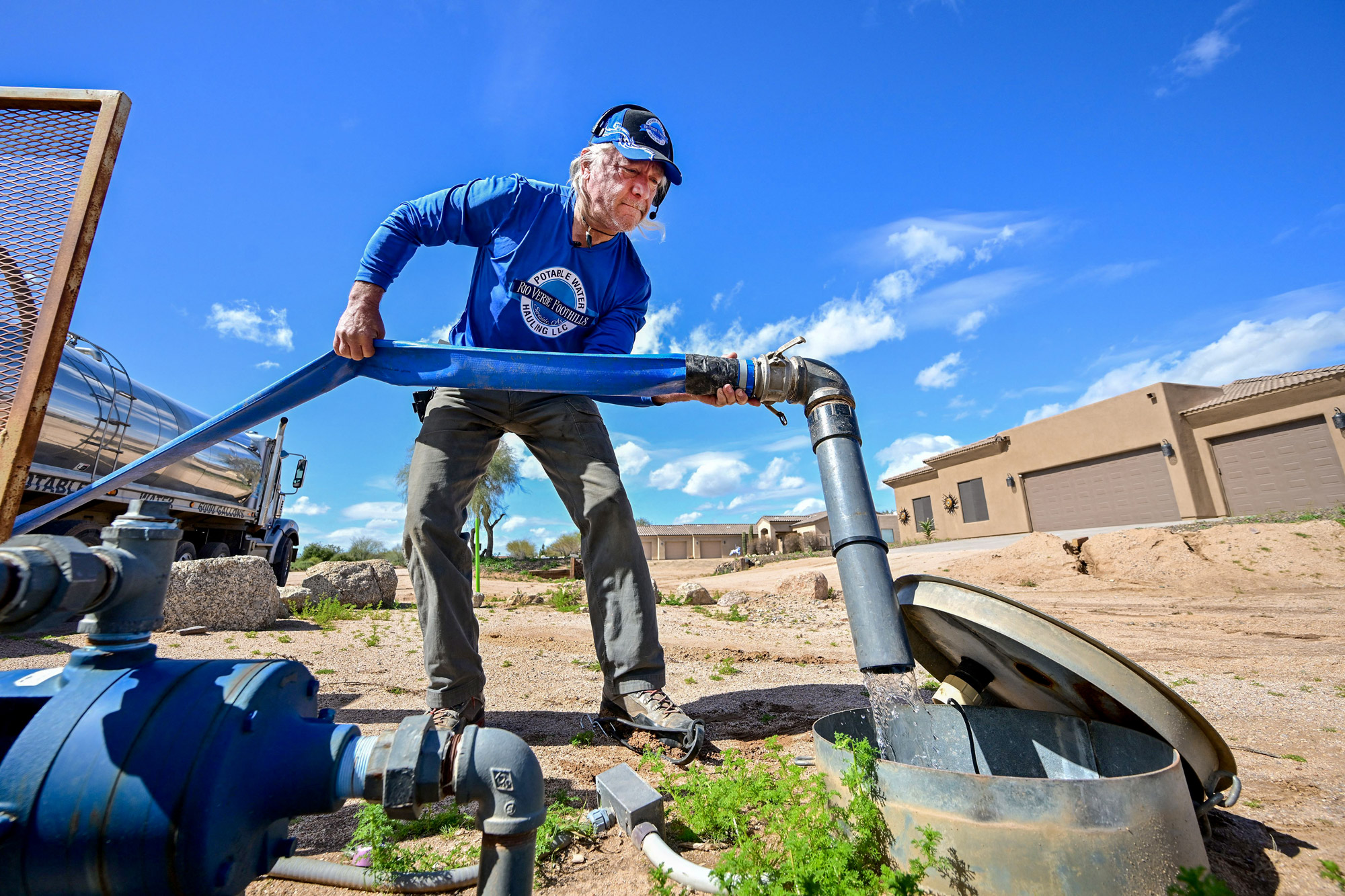 Một người đàn ông đang phân phối nước từ xe bồn của mình đến một bể chứa nước dân dụng ở Rio Verde Foothills, Arizona, vào ngày 23/02/2023. (Ảnh: Frederic J. Brown/AFP qua Getty Images)