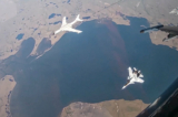 Một oanh tạc cơ tầm xa H-6K của không quân Trung Quốc, góc trên bên trái, được một chiến đấu cơ Su-30 của không quân Nga hộ tống trong một cuộc tuần tra trên không chung giữa Nga và Trung Quốc trong bức ảnh chụp từ một video phát hành hôm 25/07/2024. (Ảnh: Dịch vụ báo chí Bộ Quốc phòng Nga qua AP)