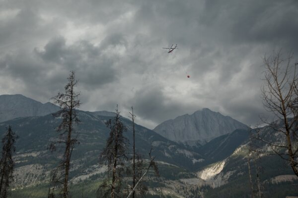 Một chiếc trực thăng đổ nước vào những đám cháy âm ỉ bên ngoài Jasper hôm 26/07/2024. (Ảnh: The Canadian Press/Amber Bracken)