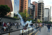 Một người biểu tình ném lại bình hơi cay khi những người ủng hộ phe đối lập Venezuela biểu tình tại Caracas, Venezuela, hôm 29/07/2024. (Ảnh: Alexandre Meneghini/Reuters)