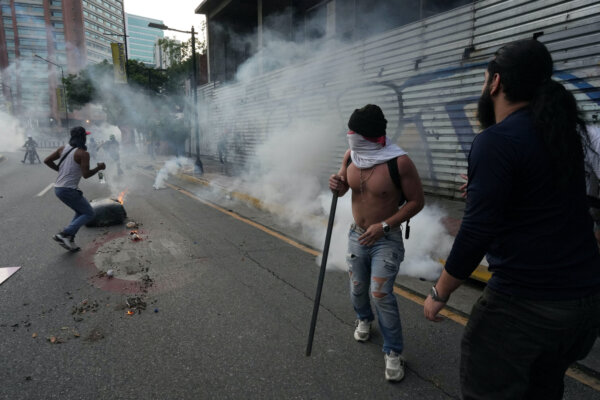 Người biểu tình chạy trốn hơi cay khi những người ủng hộ phe đối lập Venezuela biểu tình tại Caracas, Venezuela, hôm 19/07/2024. (Ảnh: Alexandre Meneghini/Reuters)
