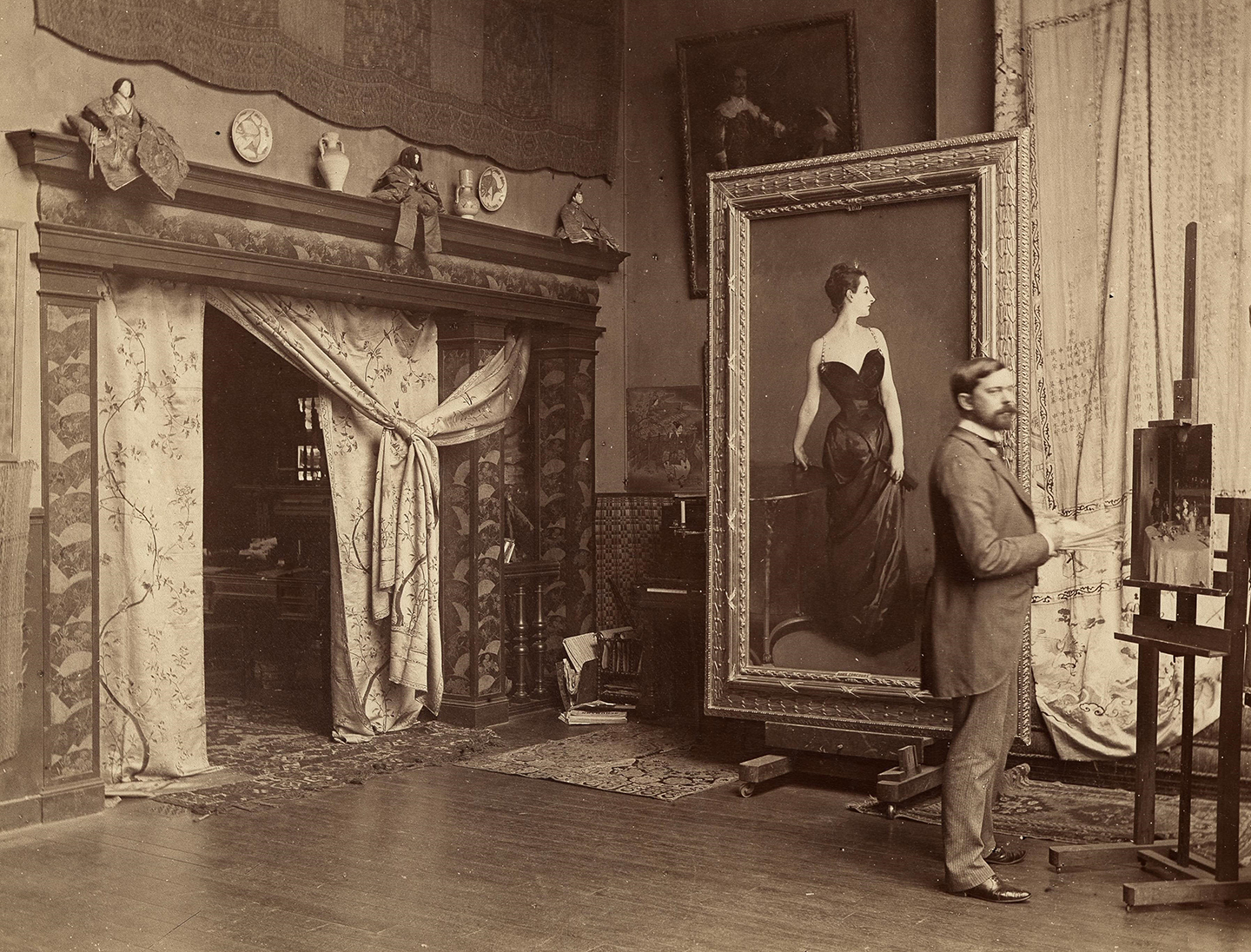 Họa sỹ John Singer Sargent bên cạnh bức tranh “Portrait of Madame X” (Chân Dung Quý Bà X) trong xưởng vẽ của mình tại Paris, năm 1885, ảnh do nhiếp ảnh gia Adolphe Giraudon chụp. (Ảnh: Tư liệu công cộng)