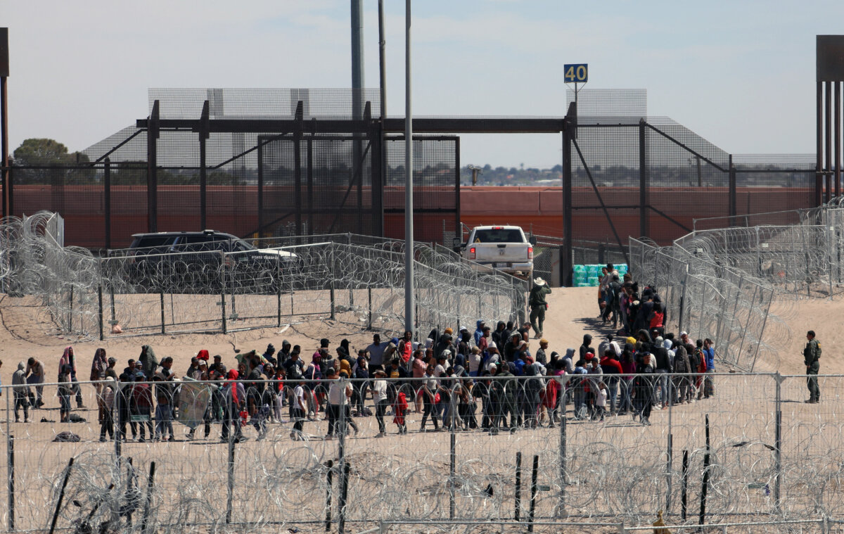 Người nhập cư bất hợp pháp xếp hàng để được Lực lượng Tuần tra Biên giới Hoa Kỳ vận chuyển sau khi vượt sông Bravo ở El Paso, Texas. Ảnh chụp từ Ciudad Juarez, Mexico, hôm 18/04/2024. (Ảnh: Herika Martinez/AFP qua Getty Images)