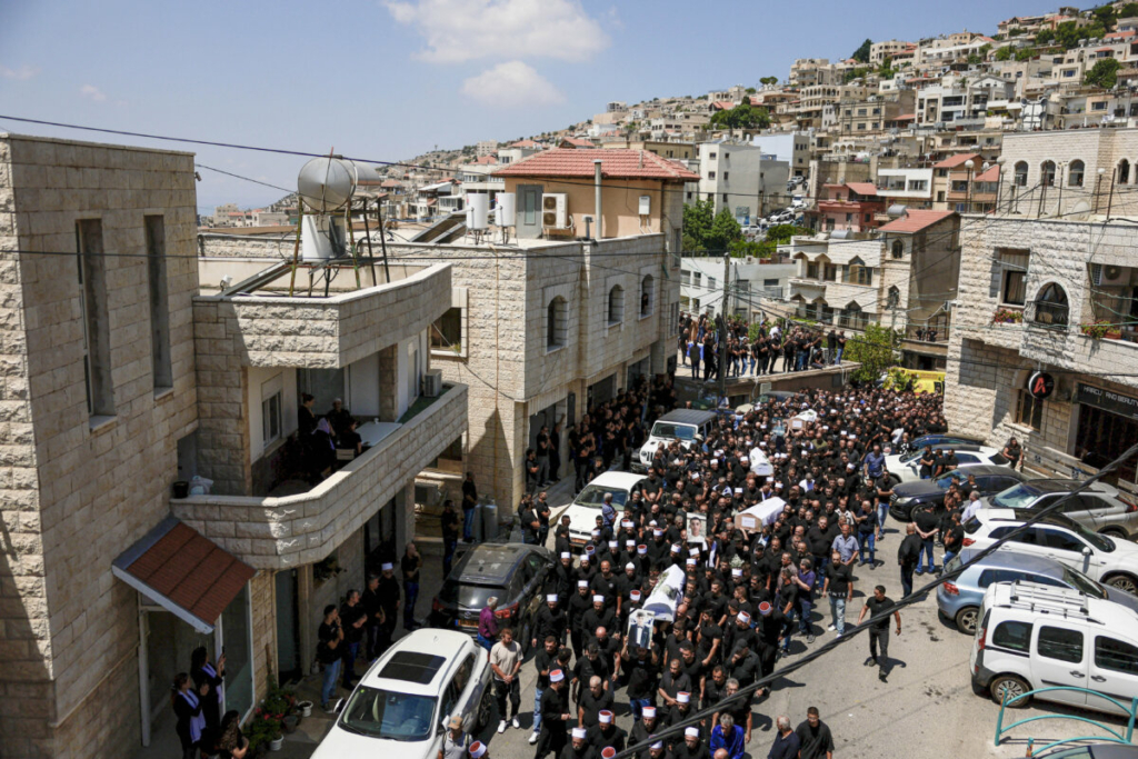 Những người đưa tang khiêng linh cữu trong lễ tang của những đứa trẻ thiệt mạng tại một sân túc cầu do một quả phi đạn mà Israel cho là được bắn từ Lebanon, ở Majdal Shams, một ngôi làng Druze thuộc Cao nguyên Golan do Israel chiếm đóng, hôm 28/07/2024. (Ảnh: Ammar Awad/ Reuters)